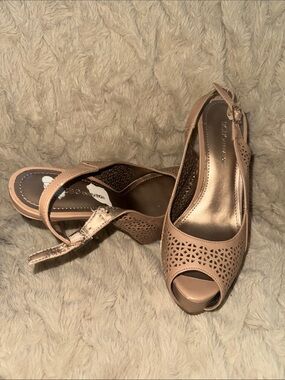 BCBGeneration laser-cut, nude slingback pumps with a peep toe.
